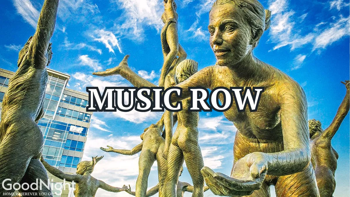 A modern building stands against a clear blue sky, fronted by striking bronze sculptures that evoke Nashville’s artistic and musical heritage. Visitors can be seen engaging with the art installations, highlighting the city’s vibrant cultural scene. The setting feels celebratory and reflective of music’s central role in Nashville’s identity.
