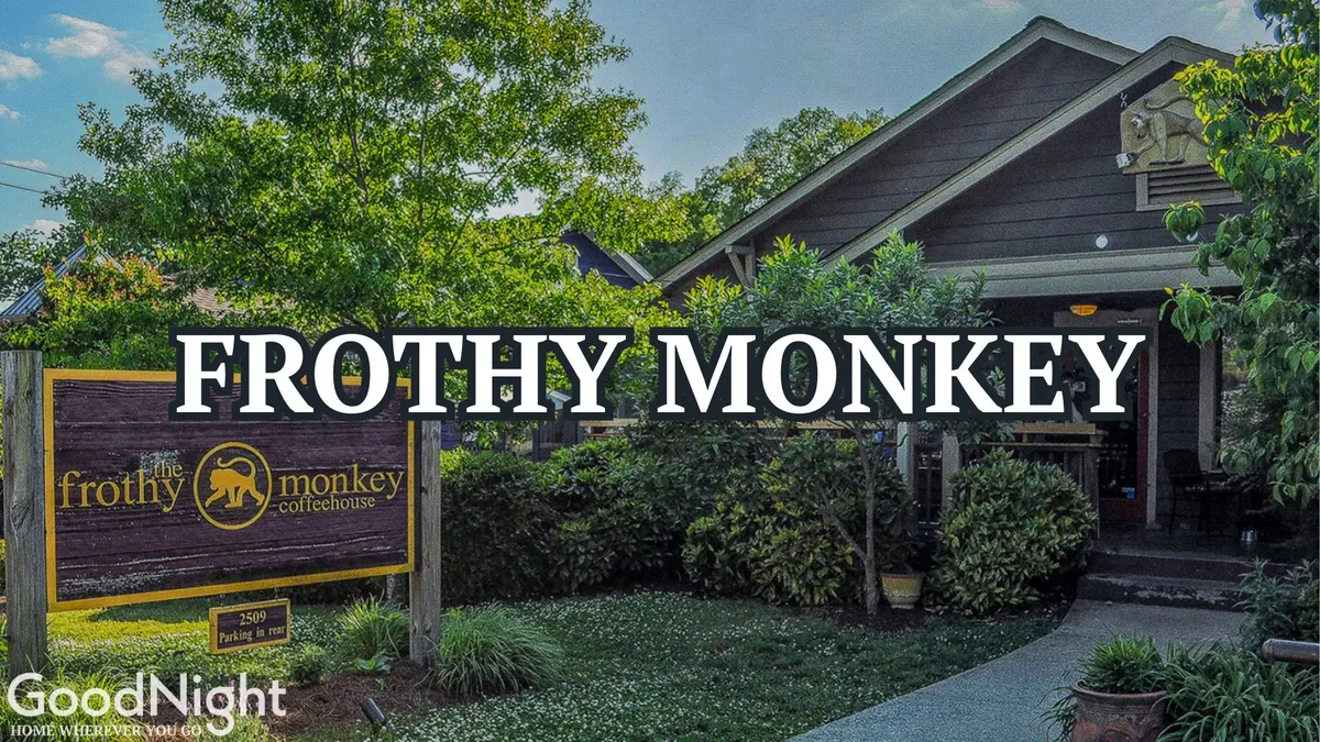 A friendly exterior view of Frothy Monkey, a well-known local coffee shop, with attractive signage, leafy surroundings, and welcoming architecture. The setting suggests a popular spot for both working remotely and unwinding after hours.